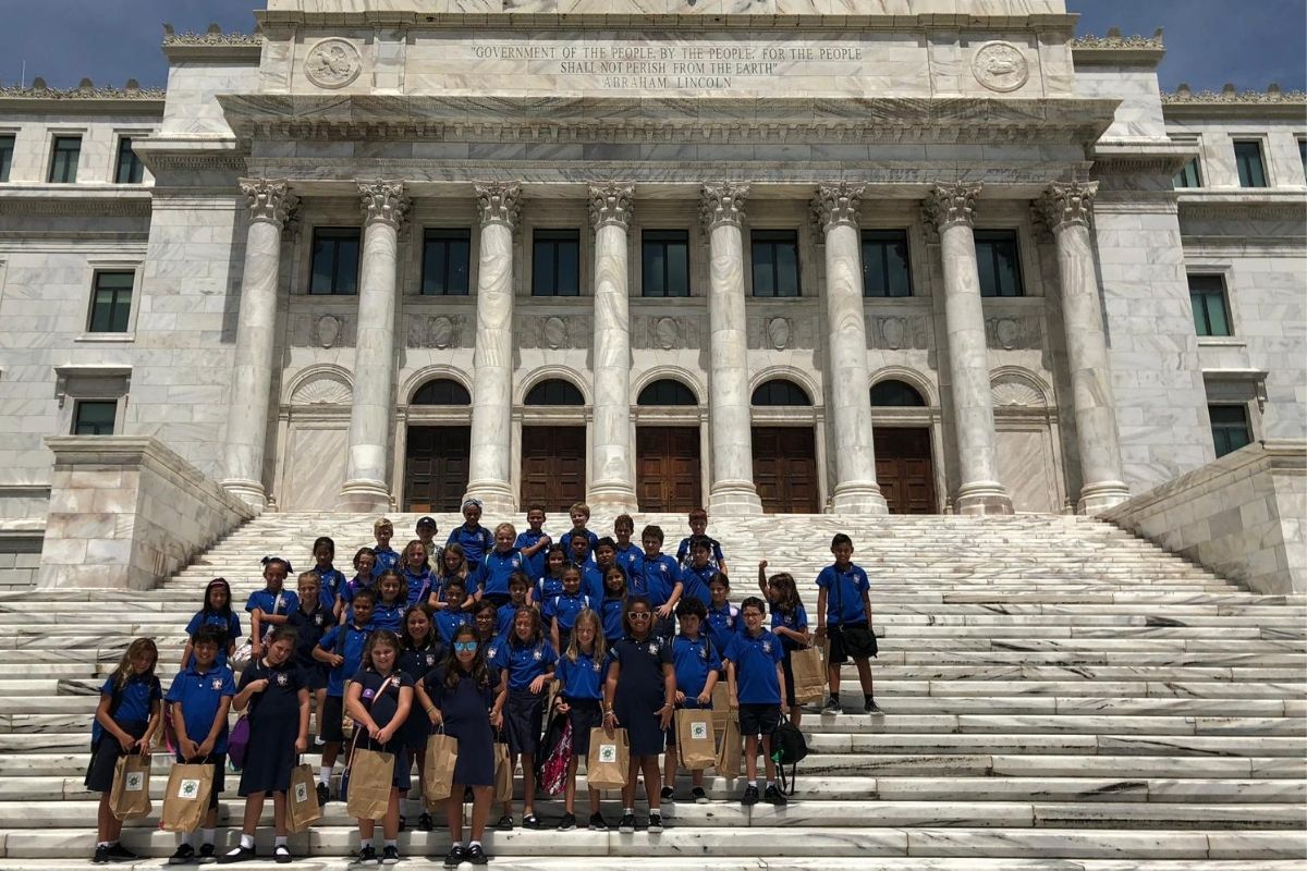 A group of Robinson School elementary students pose at the base of the Puerto Rican capitol building.