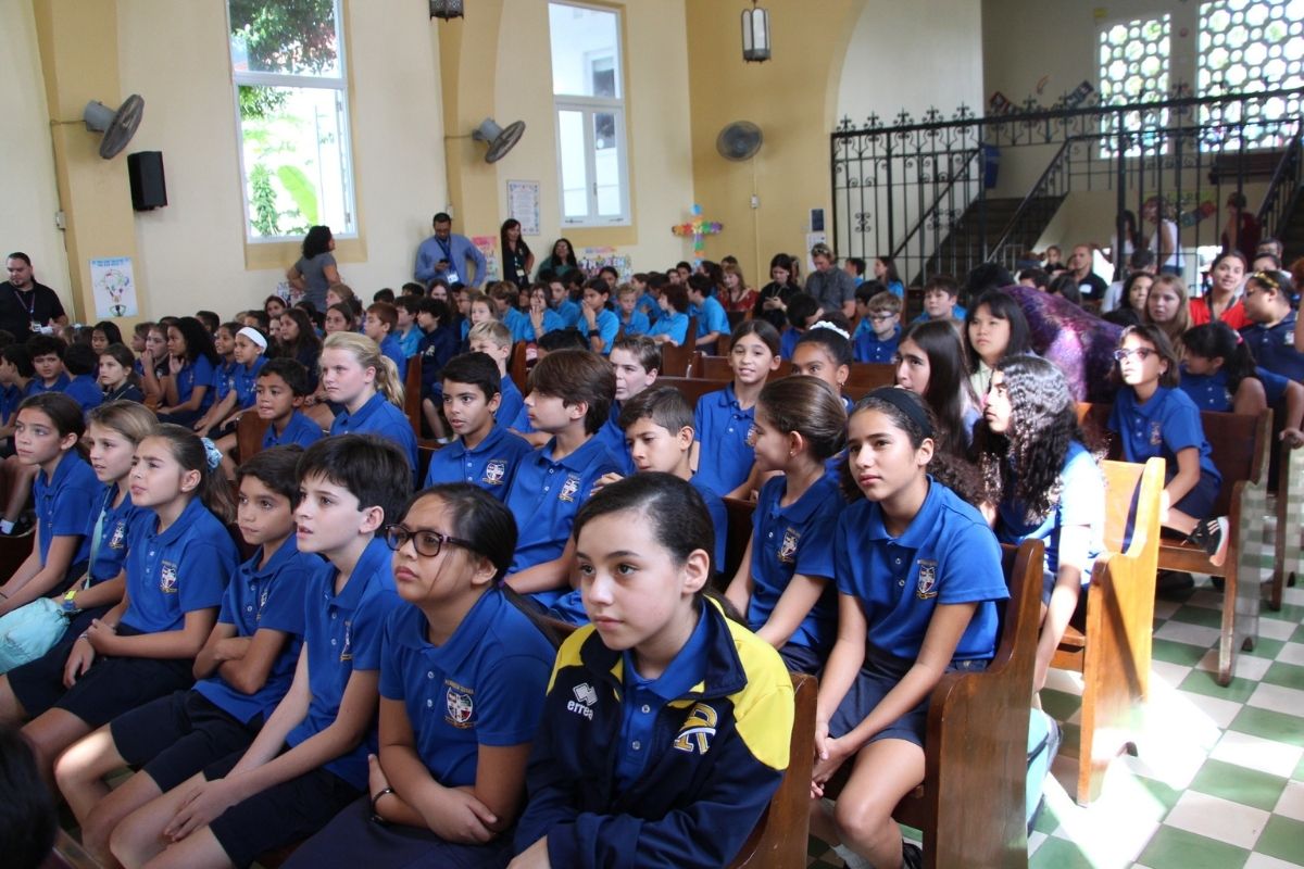 A large group of Upper Elementary Robinson School students in royal blue shirts gathered at the chapel for assembly.