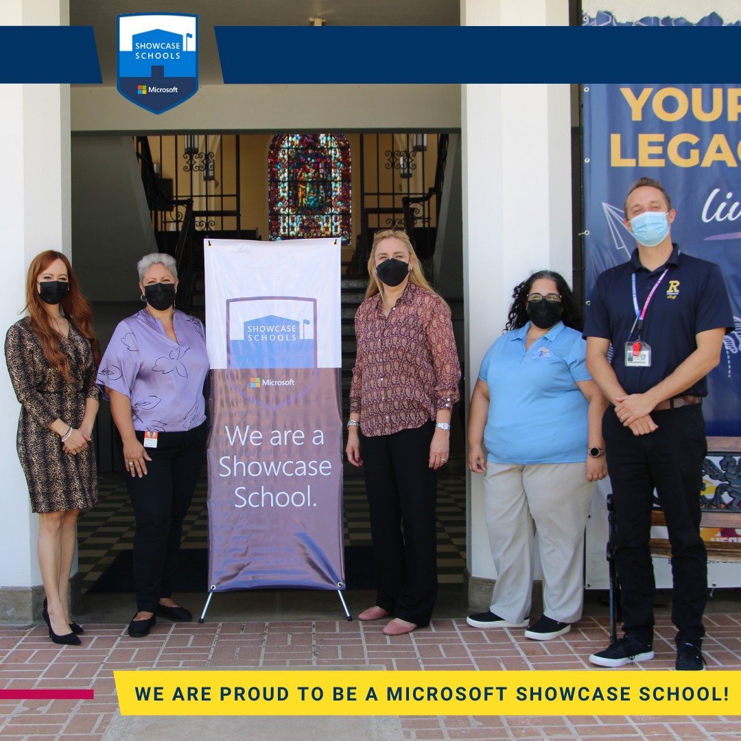 Members of Robinson School administration alongside Microsoft representatives stand next to a banner that states 'We are a Showcase School'.